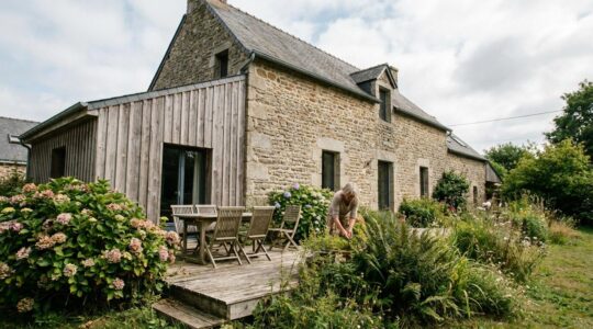Bardage bois grisaillé sur maison bretonne avec terrasse exposée et hortensias